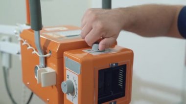 Erkek doktor eller yukarı makine x-ray hastanede kurar kapatın. Hasta olmadan kliniğinde tıbbi araçlar. Doktor backfround odak içinde değil.