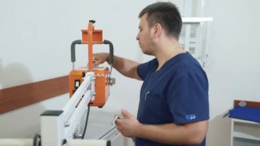 Erkek doktor bir uzaktan kumanda ile x-ray makinesi ayarlar. tıbbi ekipman ile tıbbi giysili adam. Kavramı, sağlık, hastane çalışmalarında.