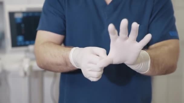 의사는 그의 손에 살 균 흰 장갑을 박 았 하 고 클램프 걸립니다. 의료 기기는 외과 의사의 손에 있습니다. 병원에 의료 장비. — 비디오
