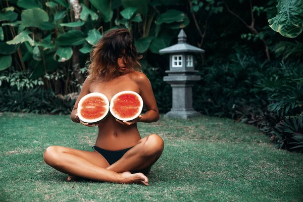 Porträt schöne brünette Mädchen im Badeanzug mit Wassermelonenfrucht hält in den Händen. sexy Model mit perfektem Körper, süßes Lächeln posiert. Konzept aus Sport, vegetarischer und gesunder Ernährung — Stockfoto
