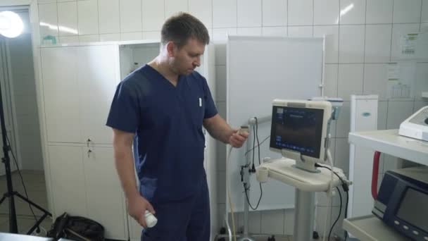 Der Chirurg im Krankenhaus führt an einem Ultraschallgerät Untersuchungen an Organen durch. Arzt zeigt medizinisches Gerät im Krankenhaus oder in der Klinik. — Stockvideo