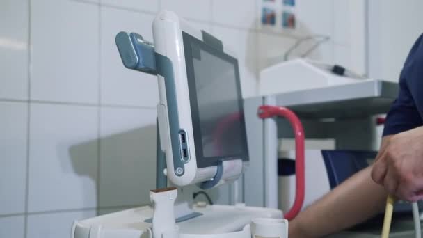 Врач в больнице работает с диагностическим оборудованием, руками крупным планом. Монитор приборов УЗИ. Медицинские инструменты в клинике . — стоковое видео