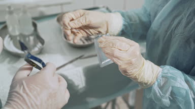 Steril tıbbi aletlerin cerrahi masa. Yardımcı'yı cerrah neşter bıçak verir. Doktorlar el cerrahi malzemeleri ile portre vurdu. Sağlık kavramı, takım çalışması hastanede.