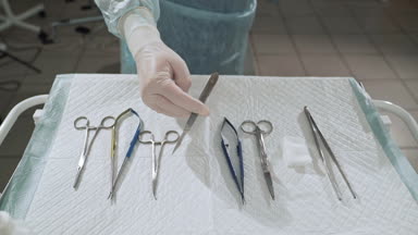 Yakın, cerrah belgesine bakın kolunu cerrahi tablosundan alır. Doktor hastanede steril araçları alın. Tıbbi ekipman operasyon öncesi hazırlanması. Sağlık kavramı