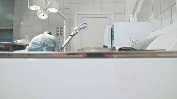 Der Chirurg arbeitet in einem Krankenhaus und bereitet vor der Operation medizinische Instrumente vor. Arzt mit Brille, professioneller Kleidung, steriler Maske und Morgenmantel. das Konzept der Gesundheit, Arbeit in der Klinik — Stockvideo