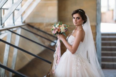 Buket çiçek beyaz lüks ile güzel gelin portresi elbise. Gelin Makyaj ve saç modeli ile bir diadem saçında, elmas küpe kulak muhteşem modeliyle. Evlilik ve floristics