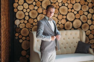 Damat Düğün gününde gidiyor, bir ceket koyar ve kolları düzeltiyor. Klasik iş elbiseleri iş ya da ofis için. İşadamı gri takım elbise ve beyaz gömlek.