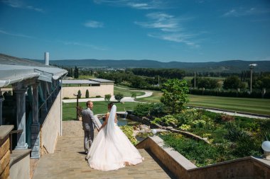 Mutlu çifte sarılma ve parkta takılıyorum. Siyah elbiseli bir papyon ve güzel bir beyaz gelinlik onun elinde bir buket ile bir gelin gelin. Güzel bir kadınla