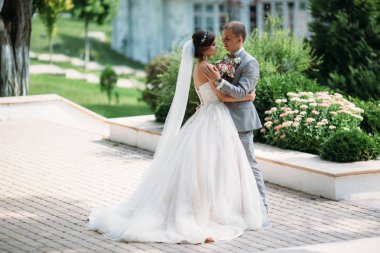 Mutlu çifte sarılma ve parkta takılıyorum. Siyah elbiseli bir papyon ve güzel bir beyaz gelinlik onun elinde bir buket ile bir gelin gelin. Güzel bir kadınla