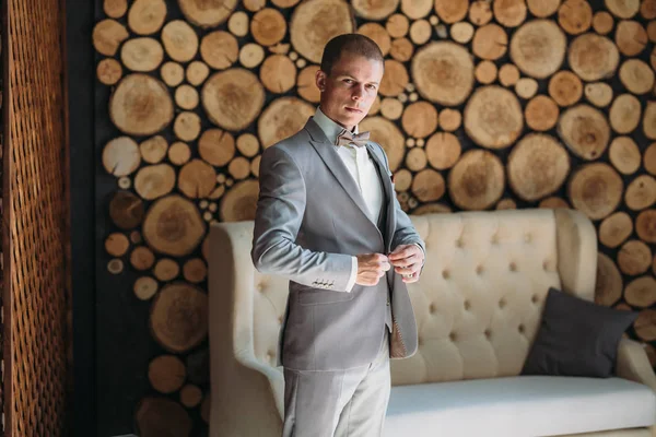 Damat Düğün gününde gidiyor, bir ceket koyar ve kolları düzeltiyor. Klasik iş elbiseleri iş ya da ofis için. İşadamı gri takım elbise ve beyaz gömlek.