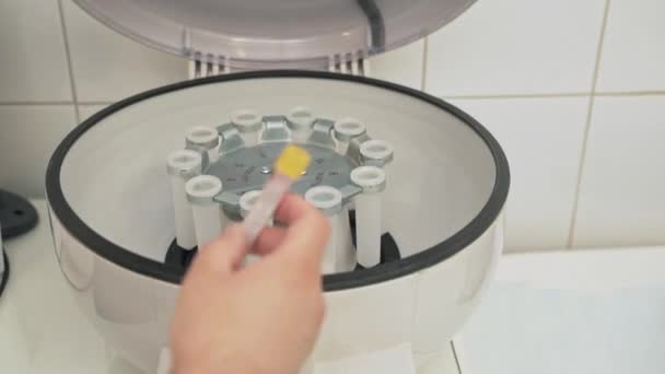 Close-up shot of electronic automatic medical blood separation test centrifuge in chemical laboratory. Doctor in professional sterile clothing works at the clinic. Hands of a man with medical — Stock Video