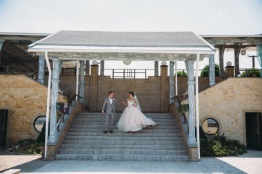 Yeni evliler açık havada düğün gününde yürüyüş mesafesindedir. Damat ile beyaz bir gömlek ve bir papyon gri elbiseli çok güzel bir gelin bir örtü ile lüks beyaz elbise ile onun elinde tutar. Kızla yapmak