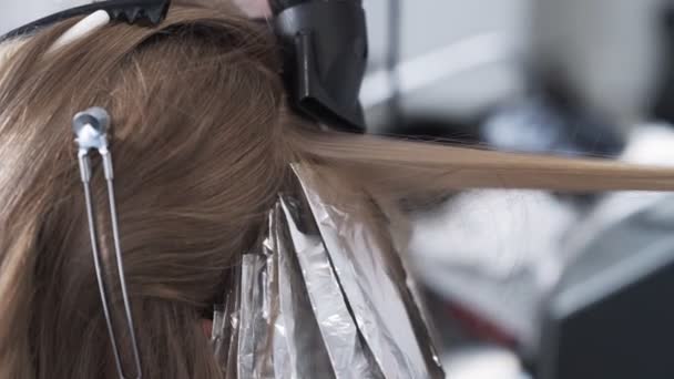 Close up, cabeleireiro seca o cabelo da mulher com secador de cabelo durante a coloração do cabelo — Vídeo de Stock