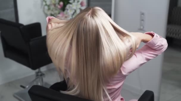 Slow-motion schieten van een lang blond haar van een jong meisje, achterzijde uitzicht — Stockvideo