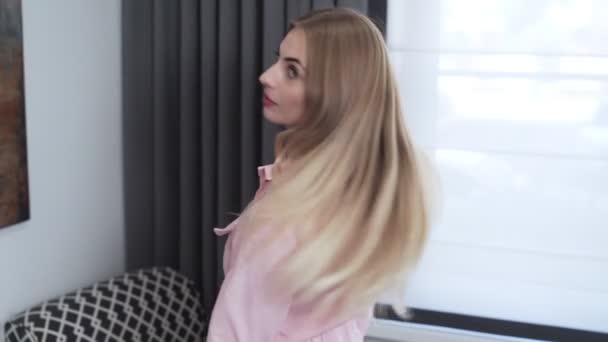 Bella giovane donna mostra i suoi lunghi capelli biondi prima della procedura di tintura dei capelli — Video Stock