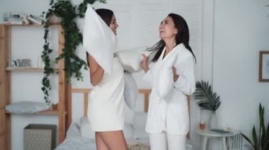Yatak odasına atlayan iki kız ve evde yastıklarla dans eden, komik bir video.