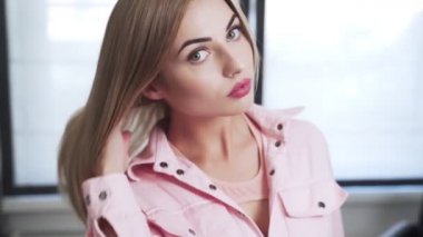 Güzel genç bayan saç boyama işleminden önce uzun sarı saçlarını gösterir.