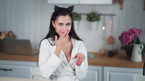 Porträtt av kvinna i badrock applicerar kräm på ansiktet och gör ansiktsmassage — Stockvideo