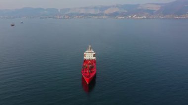 Kırmızı renkli, ultra büyük, denizde boş bir kargo gemisinin havadan çekilmiş görüntüleri.