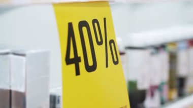 Kapalı, sarı posterli, büyük indirimli, kozmetik ürünlerle dolu.