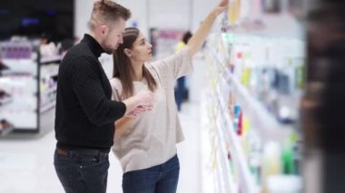 Genç adam ve kadın kozmetik ürünlerini mağazada seçti, aile alışverişi konsepti.