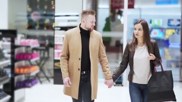 Man och kvinna gå runt köpcentret hålla händer och prata, steadicam skott — Stockvideo