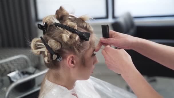 Close up, kapper kammen lang blond haar van cliënt met borstel — Stockvideo