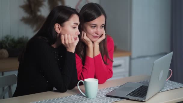 Aburrido jóvenes amigas viendo vídeo en el ordenador portátil en casa, discutiéndolo — Vídeos de Stock