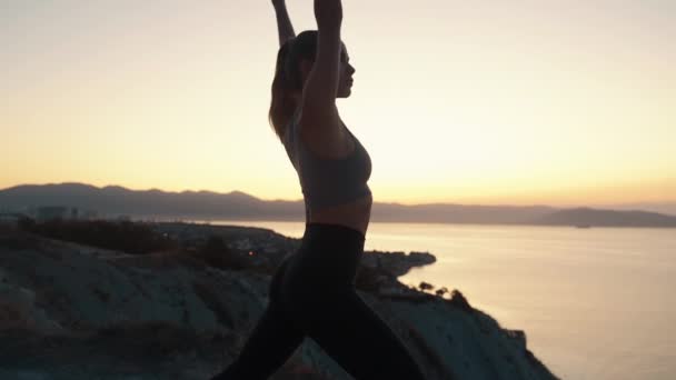 Silhouette de la femme faisant des étirements tôt le matin dans le rayon de soleil, au ralenti — Video