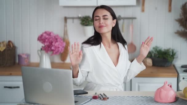 Vrouw luisteren naar muziek op laptop en dansen in de keuken thuis — Stockvideo