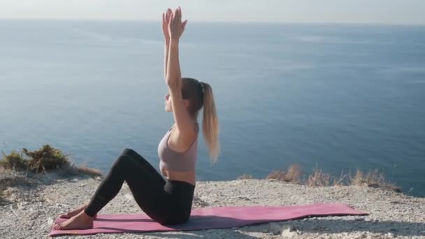 Frau macht morgens Übungen und dehnt sich mit Blick aufs Meer, Zeitlupe — Stockvideo