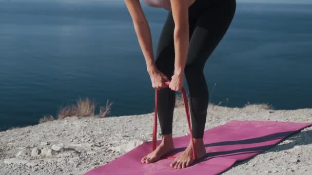 Woman teszi edzés gumiszalag a szabadban, vonatok testét, lassú mozgás — Stock videók