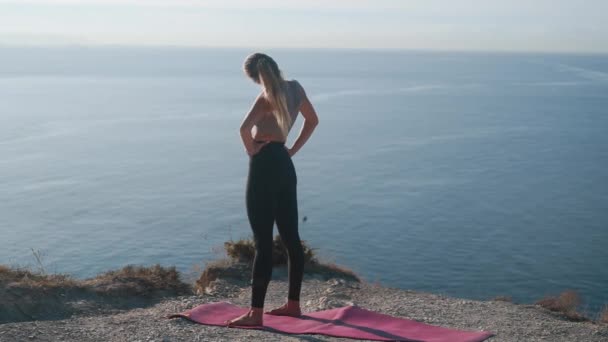 Femme fait des exercices et s'étend le matin avec vue sur la mer, au ralenti — Video