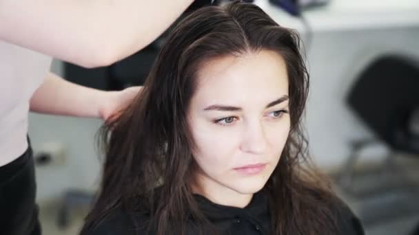 Detail rukou kadeřníka hřebeny mokré vlasy dívky v salonu krásy — Stock video
