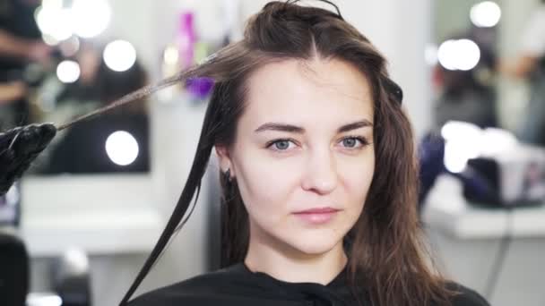 Da vicino, le mani di parrucchiere applicano cheratina a capelli di donna — Video Stock