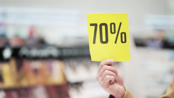 De cerca, la mano masculina sostiene cartel amarillo con signo de descuento, gran venta — Vídeo de stock