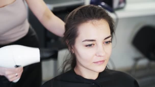 De cerca, la peluquería seca el cabello húmedo de la mujer con secador de pelo en el salón de belleza — Vídeo de stock