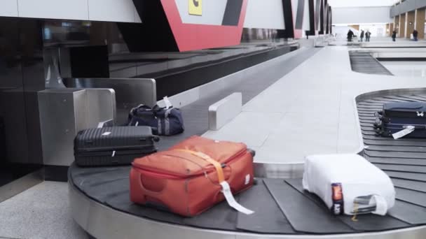 Luggage on a conveyor belt in the baggage claim area of international airport — Stock Video