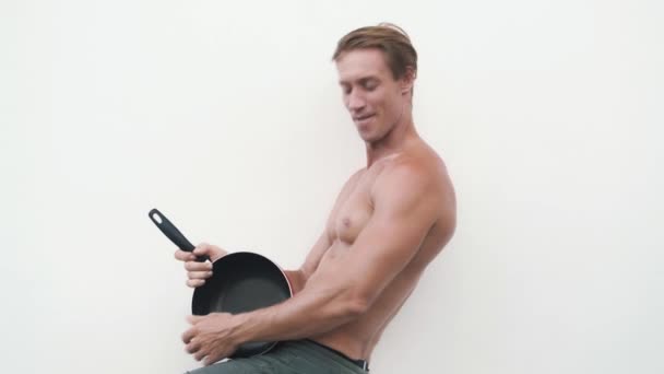 Shirtless σέξι άντρας με τηγάνι τη χρησιμοποιεί σαν κιθάρα, παίζει, αστείο βίντεο — Αρχείο Βίντεο