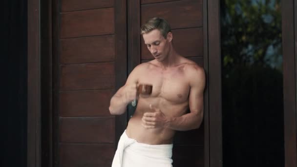 Sukně bez trička sexy svalnatý muž pije kávu na dvoře domu v dopoledních hodinách — Stock video