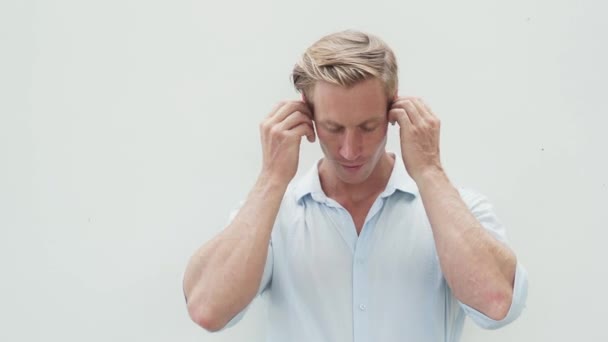 Retrato de homem colocando fones de ouvido sem fio, ouvindo música, dançando — Vídeo de Stock