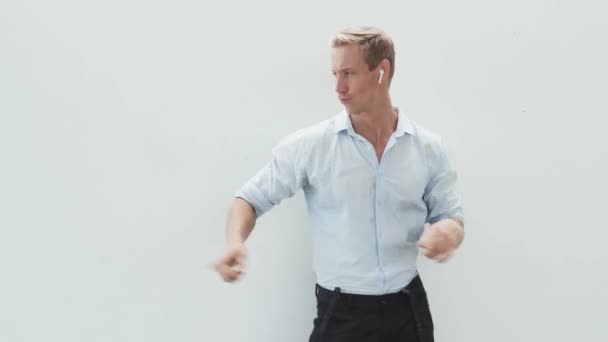 Человек слушает музыку с беспроводными наушниками, танцует, двигает руками, чтобы бить — стоковое видео