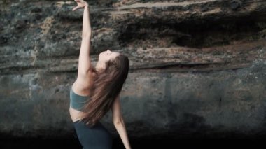 Şehvetli genç bir kadının portresi kameraya bakar ve ellerini yavaşça hareket ettirir.