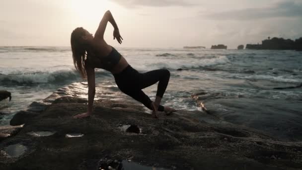 Femme faisant des exercices d'étirement sur la plage, océan sur fond, ralenti — Video