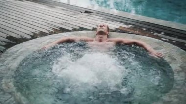 Seksi erkek dışarıda jakuzide rahatlar ve yavaş çekimde eğlenir.