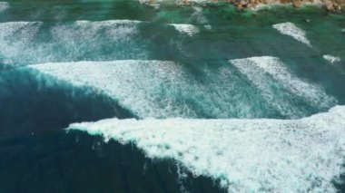 Devasa okyanus dalgalarının çarpışma ve köpürme görüntüsü..