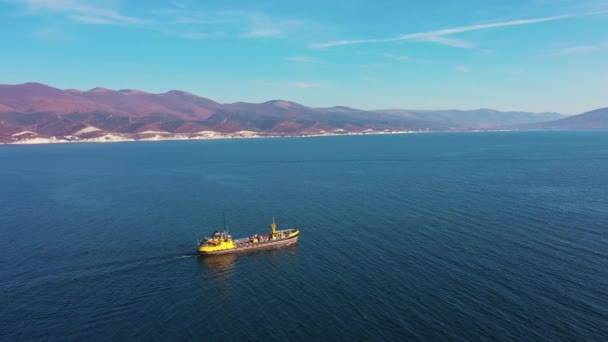 Vista aérea tras el ultra gran buque de carga en el mar sale del puerto al atardecer — Vídeos de Stock