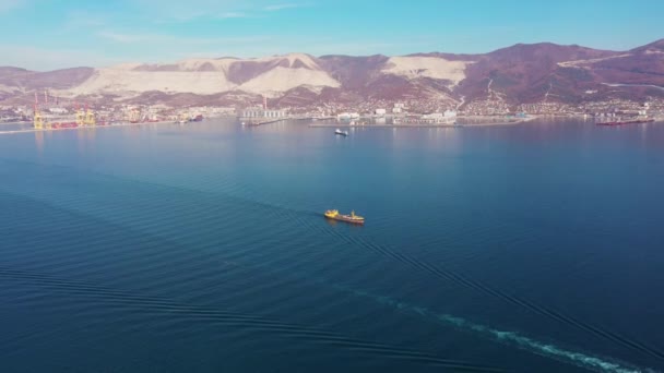 Vue aérienne l'ultra grand cargo en mer quitte le port au coucher du soleil zoomant . — Video