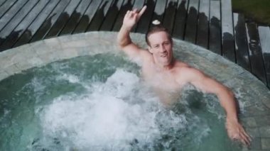 man has fun in jacuzzi during vacation at tropical resort