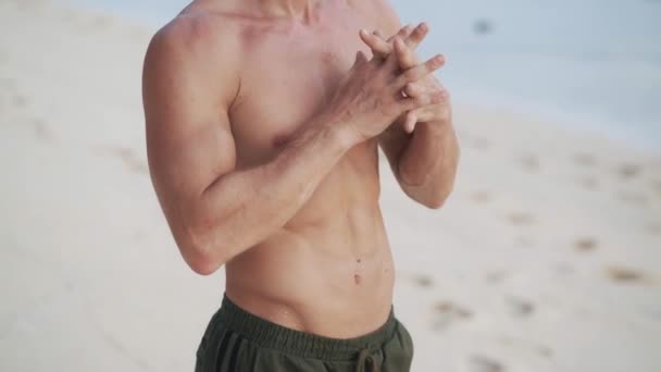 Bare torso man does warm-up before yoga exercise on beach — Stock videók